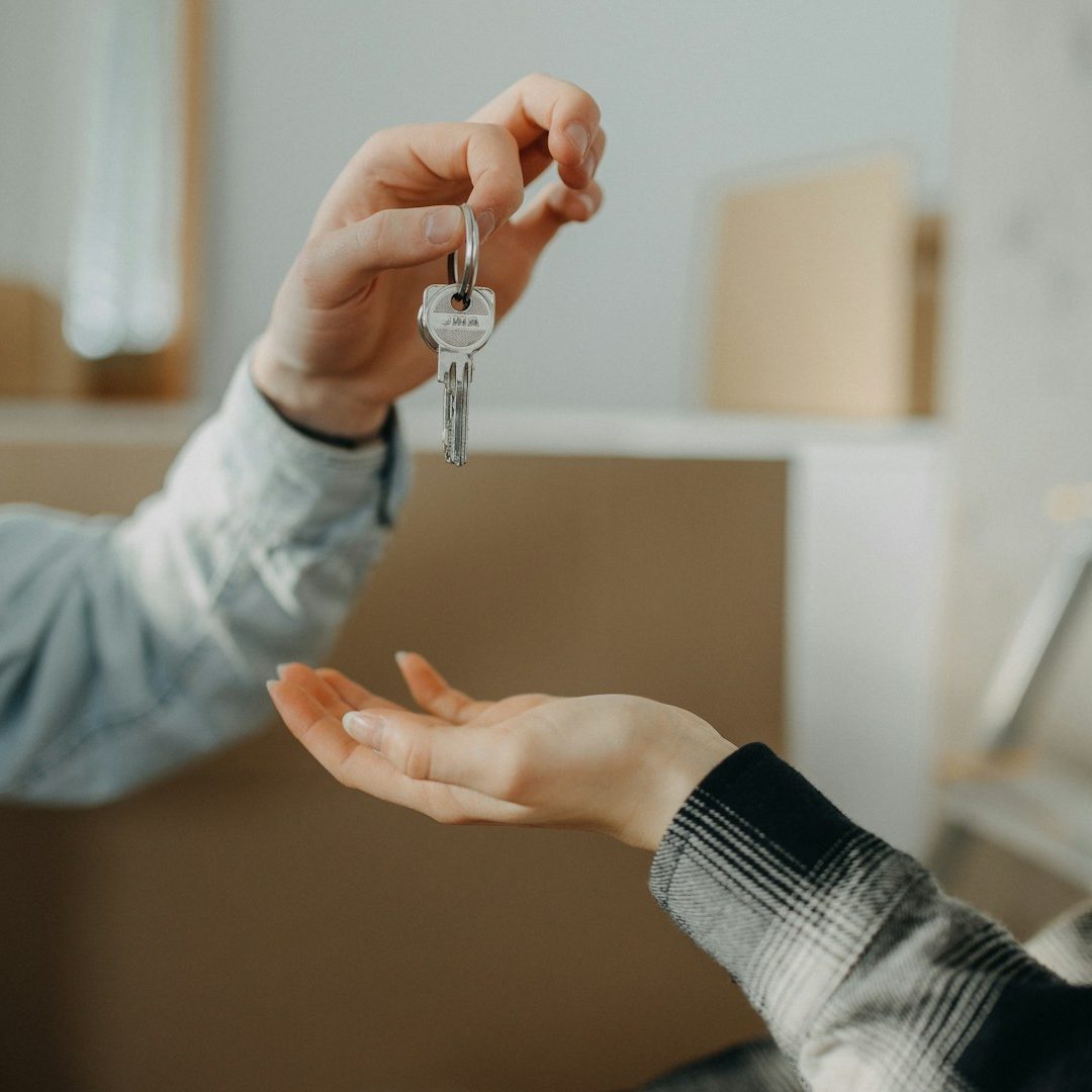 Ein Schlüssel wird von einer Hand an eine andere übergeben.