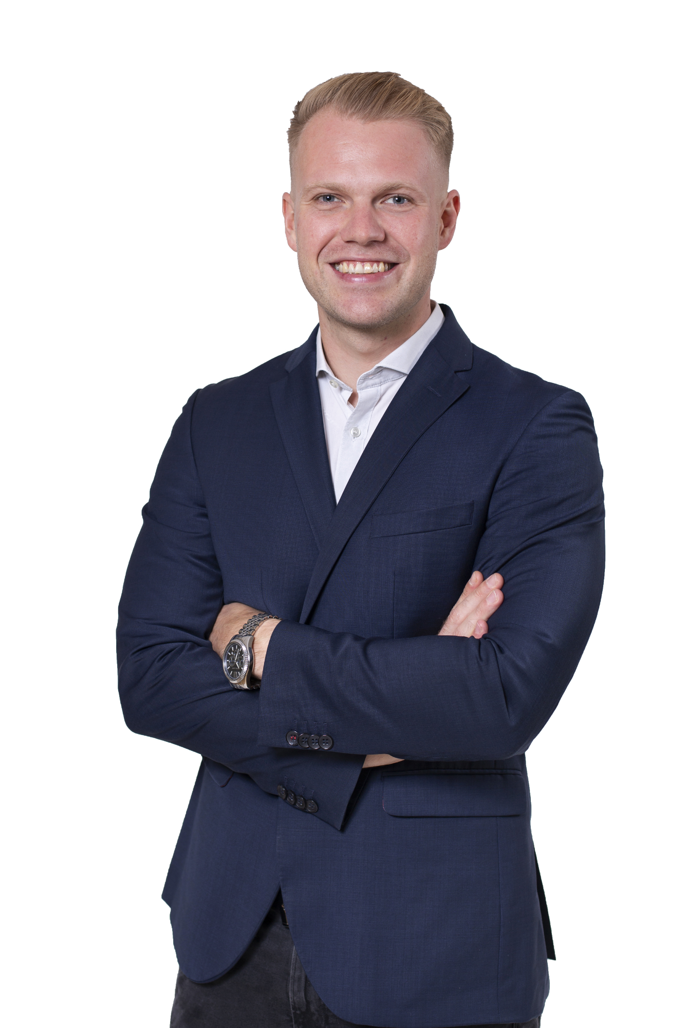 Sachverständiger Elias Barlag Mann mit lächelndem Gesicht, verschränkten Armen in Anzug und Hemd, vor weißem Hintergrund.